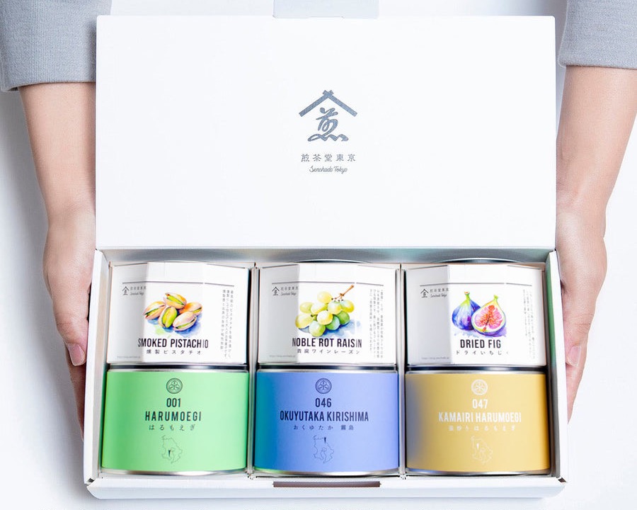 煎茶堂東京のギフトボックス。ふたを開けた箱に、色とりどりの茶缶が三つ並ぶ