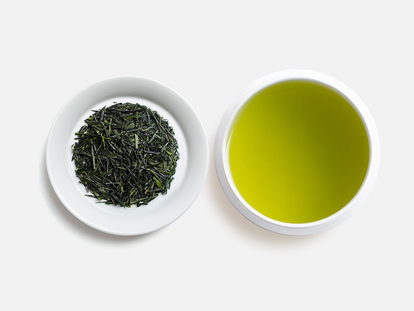 白い小皿に盛られた煎茶の茶葉と、碧い水色のお茶を注いだ湯呑み